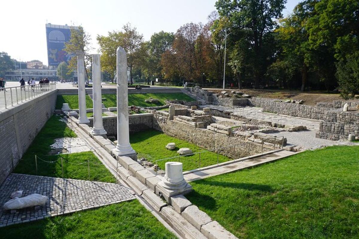 Un cementerio con columnas y césped en un parque.