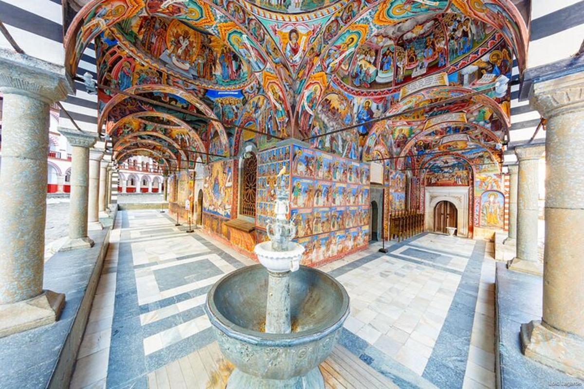 uma sala com uma fonte em um prédio com tetos pintados