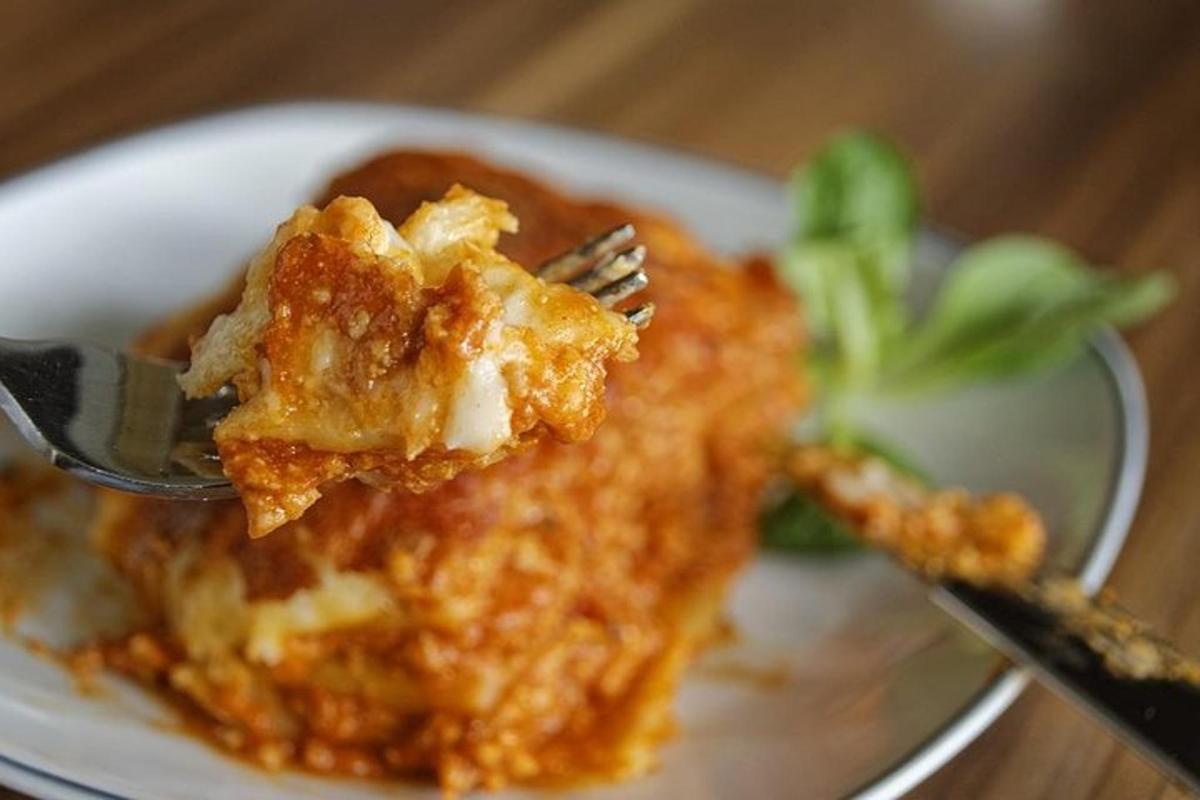 una forchetta che tiene un pezzo di cibo su un piatto