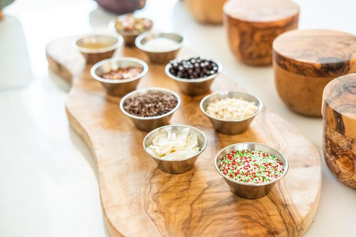 a wooden cutting board topped with small bowls of sprinkles