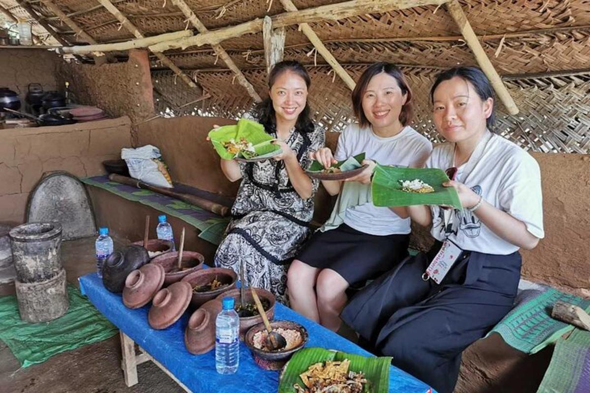 three women sitting on a couch holding plates of food
