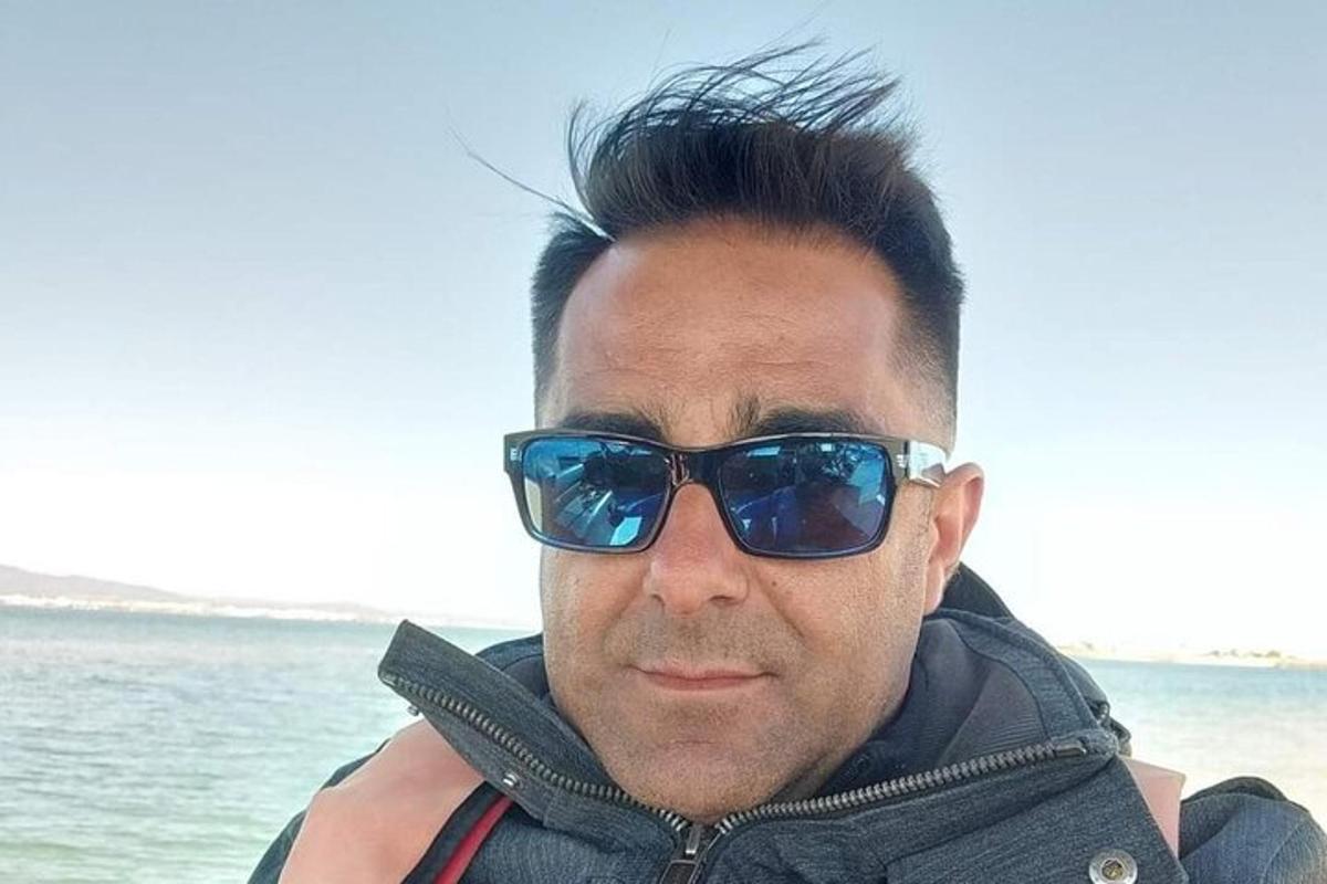 Maður með sólgleraugu stendur fyrir framan vatnið