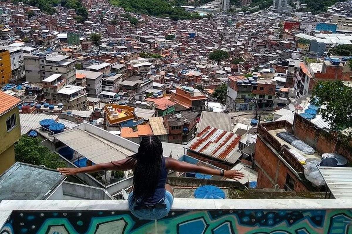 seorang wanita duduk di atas tebing sambil melihat sebuah bandar