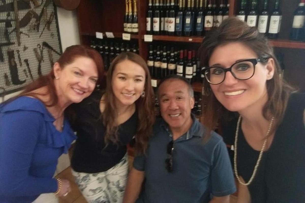 a group of three women and a man posing for a picture