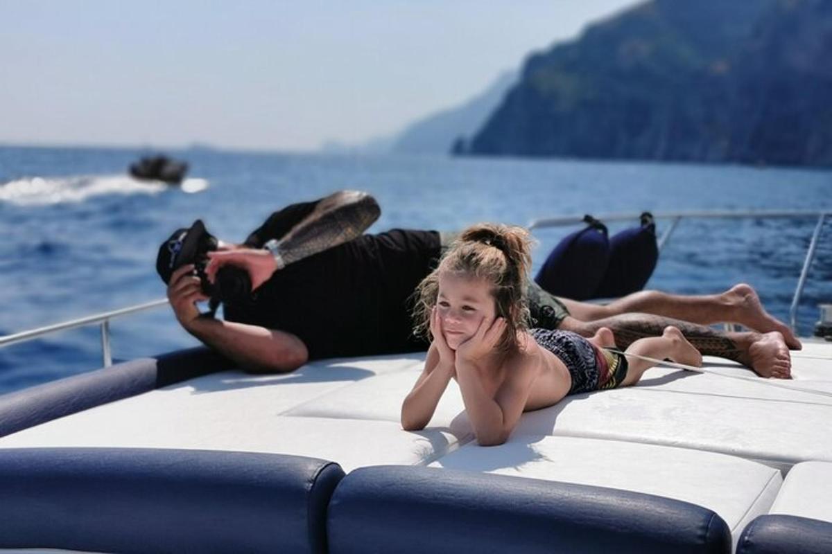 un uomo e una ragazza sdraiati sul retro di una barca