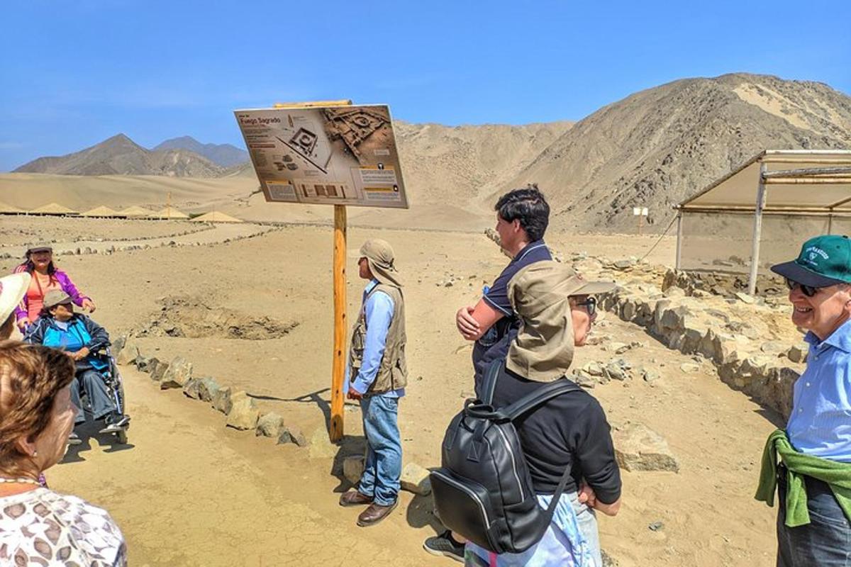 un gruppo di persone in piedi attorno a un cartello nel deserto