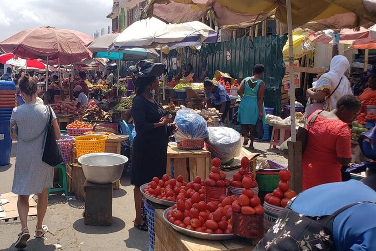 a woman standing in a market with fruit and vegetables