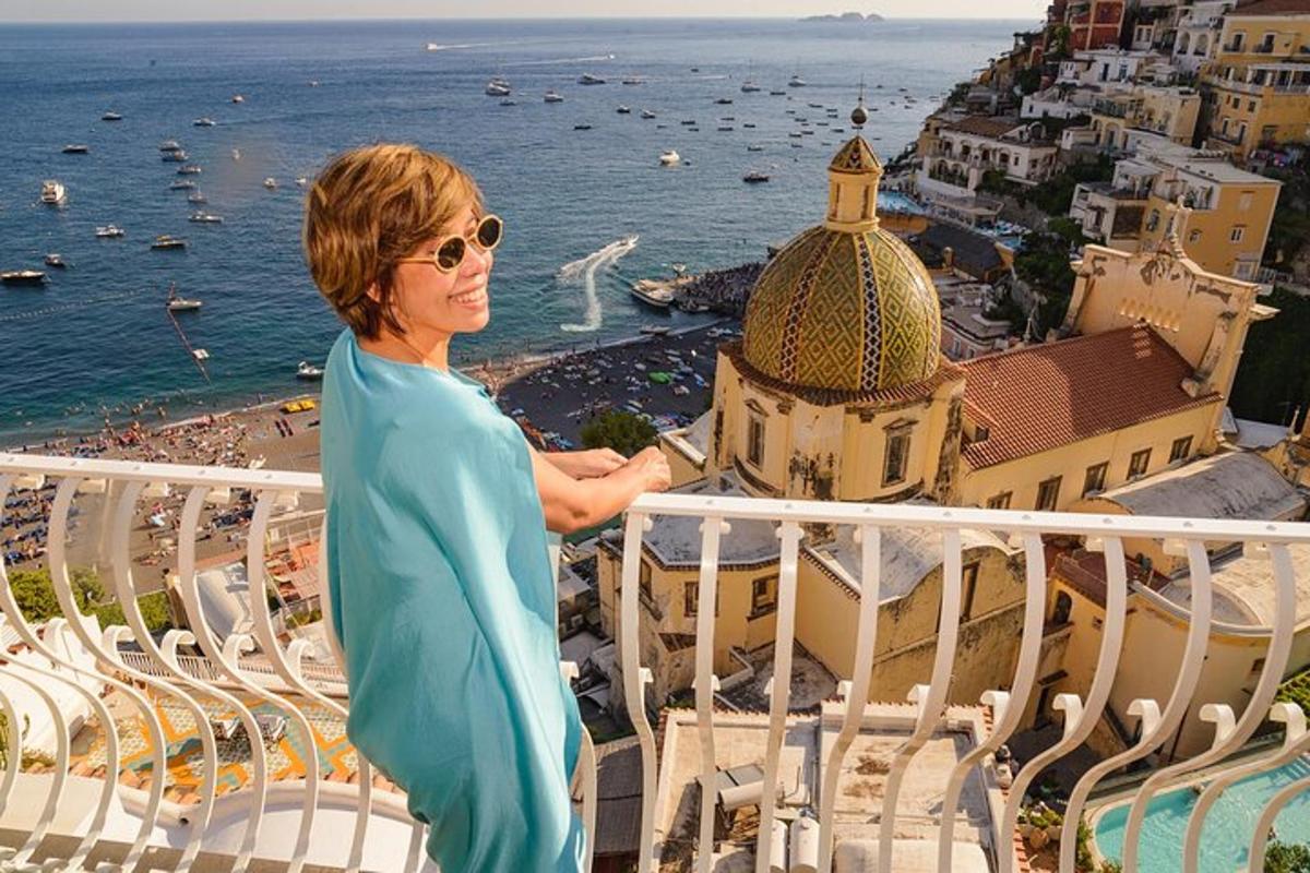 una donna in piedi su un balcone che guarda l'oceano