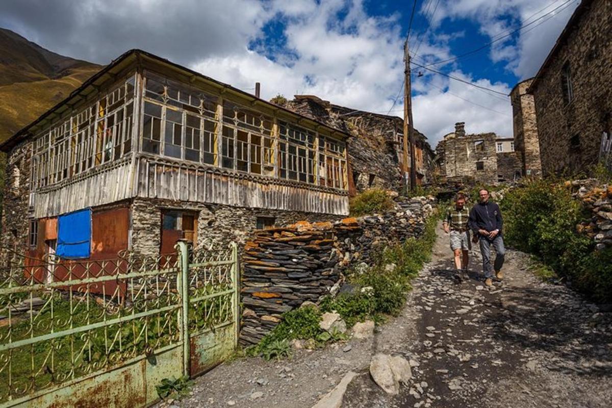 two people walking in front of a stone building