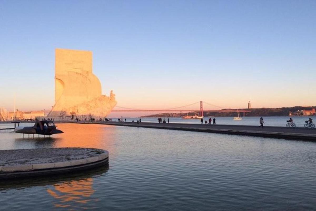 una posta de sol sobre l'aigua amb un monument al fons