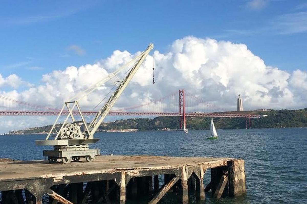 una gru su un molo con un ponte sullo sfondo