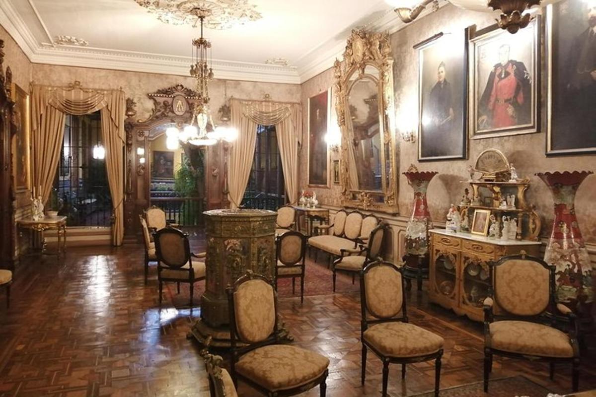 velká místnost s židlemi a portréty na stěnách