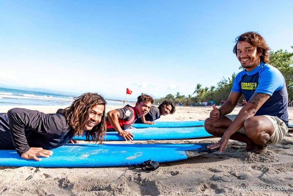 Un grupo de personas tumbadas sobre tablas de surf en la playa.