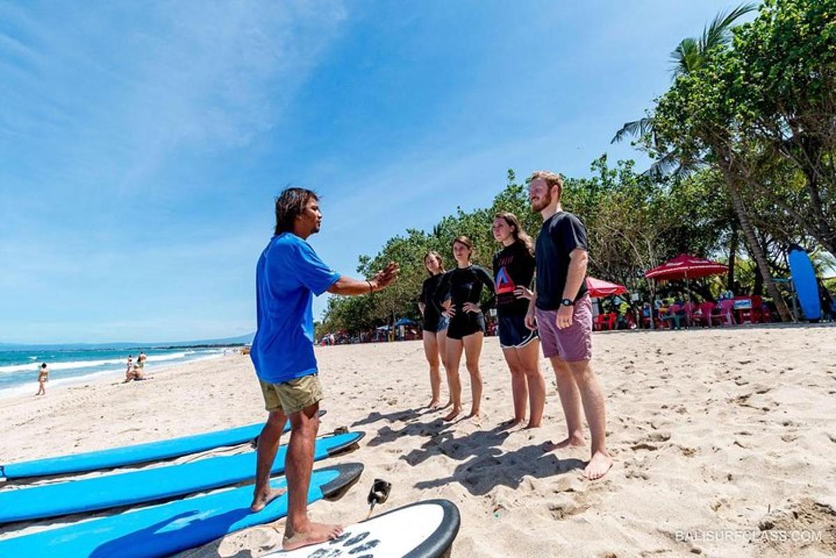 un groupe de personnes debout sur une plage avec des planches de surf
