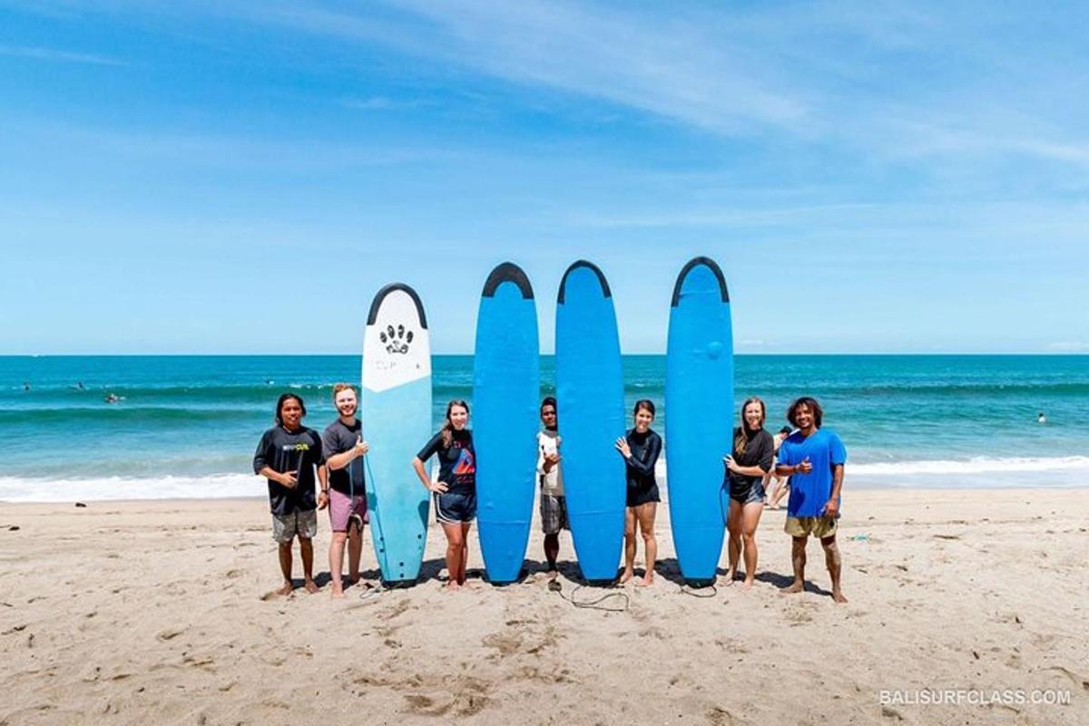 Grupa ludzi stojąca przed deskami surfingowymi na plaży