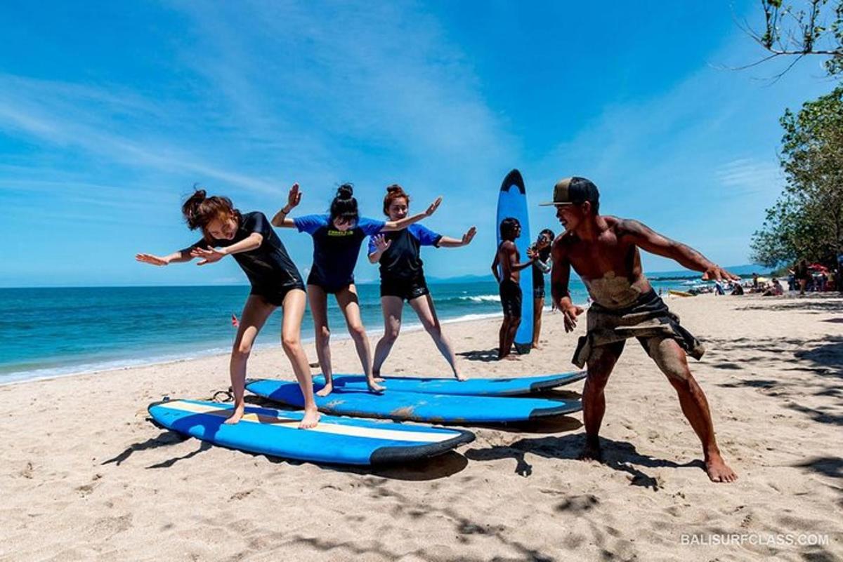a group of people standing on surfboards on the beach