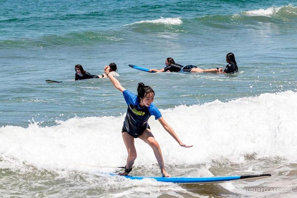 Una mujer montando una ola en una tabla de surf en el océano