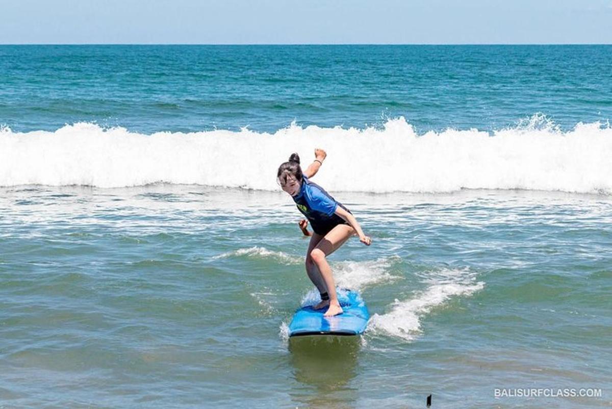 Una niña montando una ola en una tabla de surf en el océano