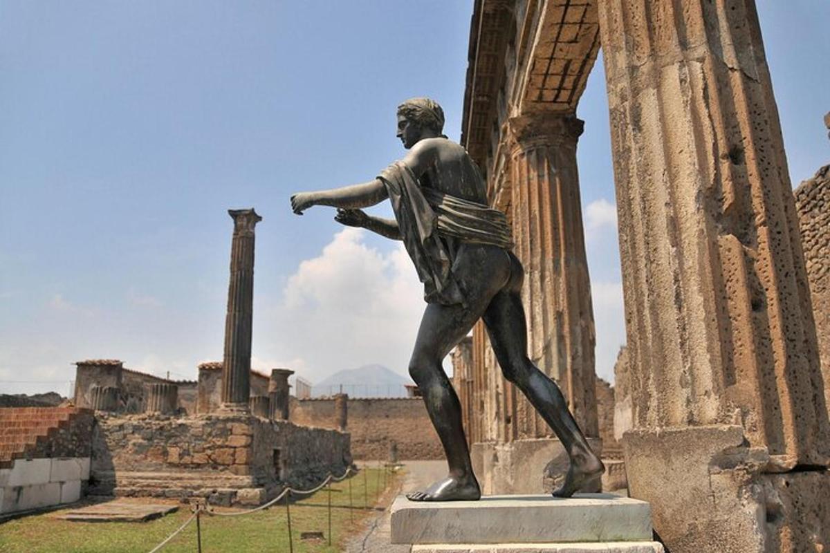 Una estatua de un hombre de pie junto a una columna.
