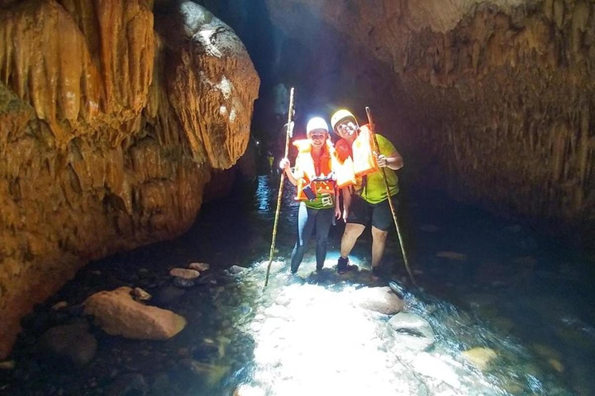 двама души, стоящи във водата в пещера