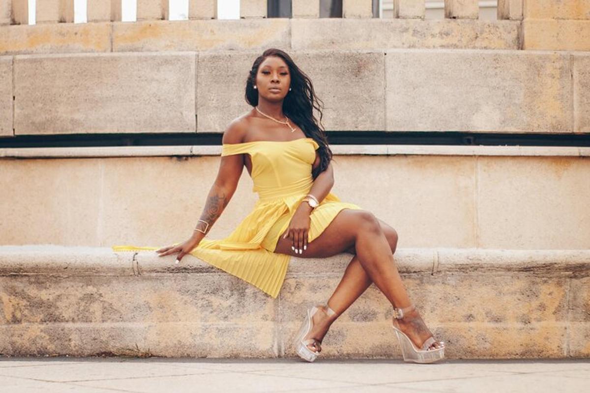 a woman in a yellow dress sitting on some steps