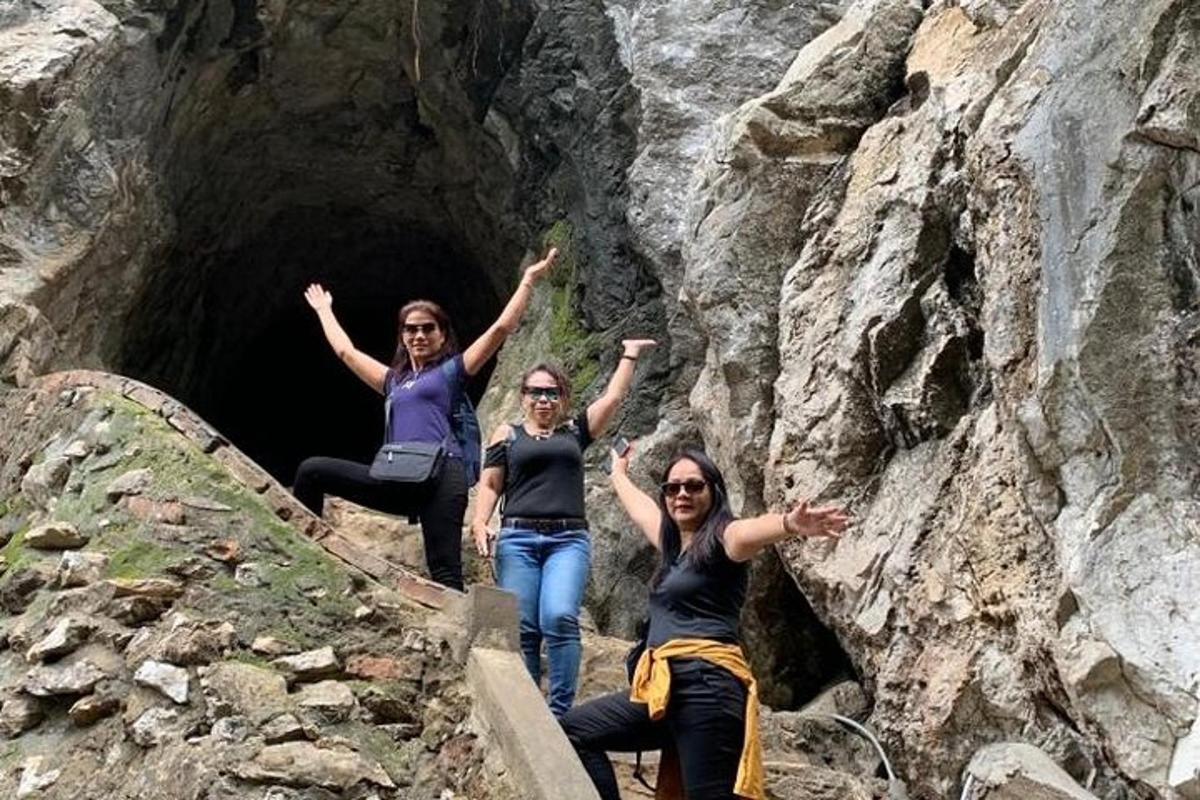 un grup de tres dones dempeus davant d'una cova