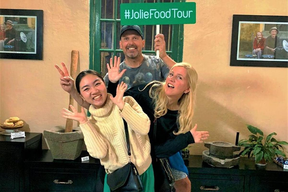 a man and two women standing with their hands up