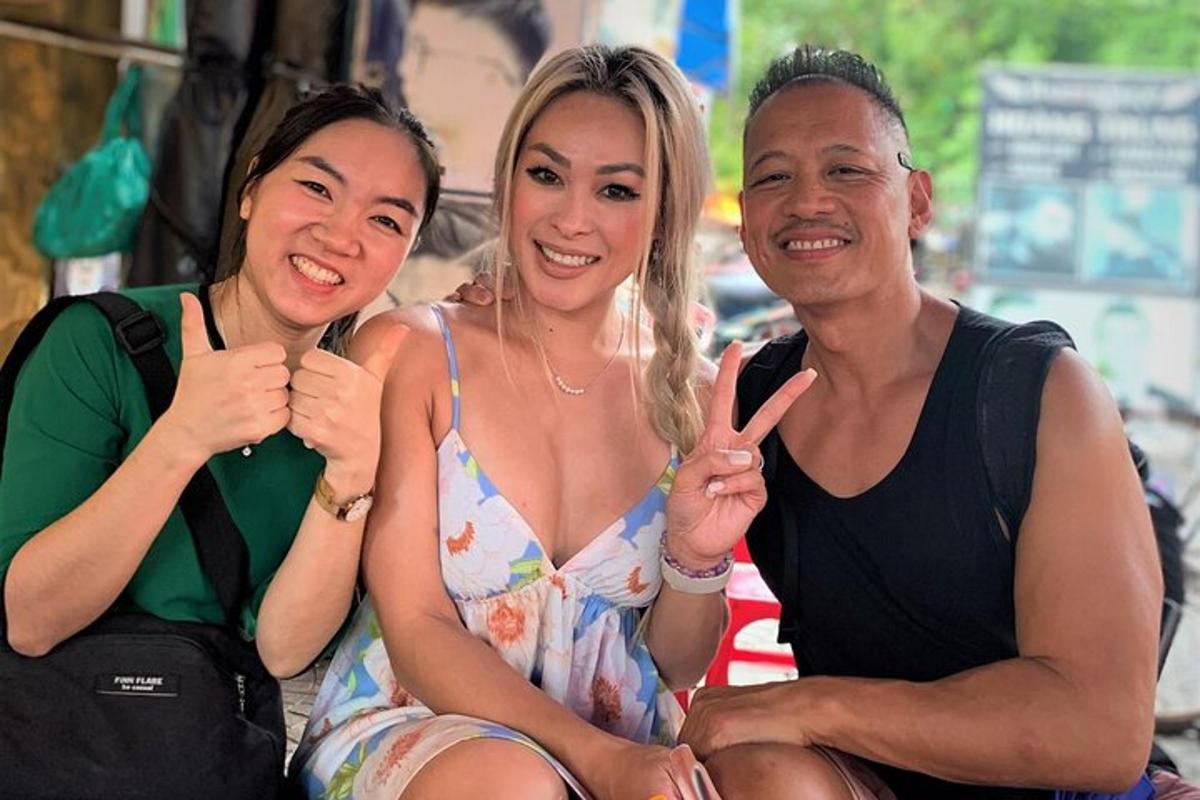 two women and a man giving the peace sign