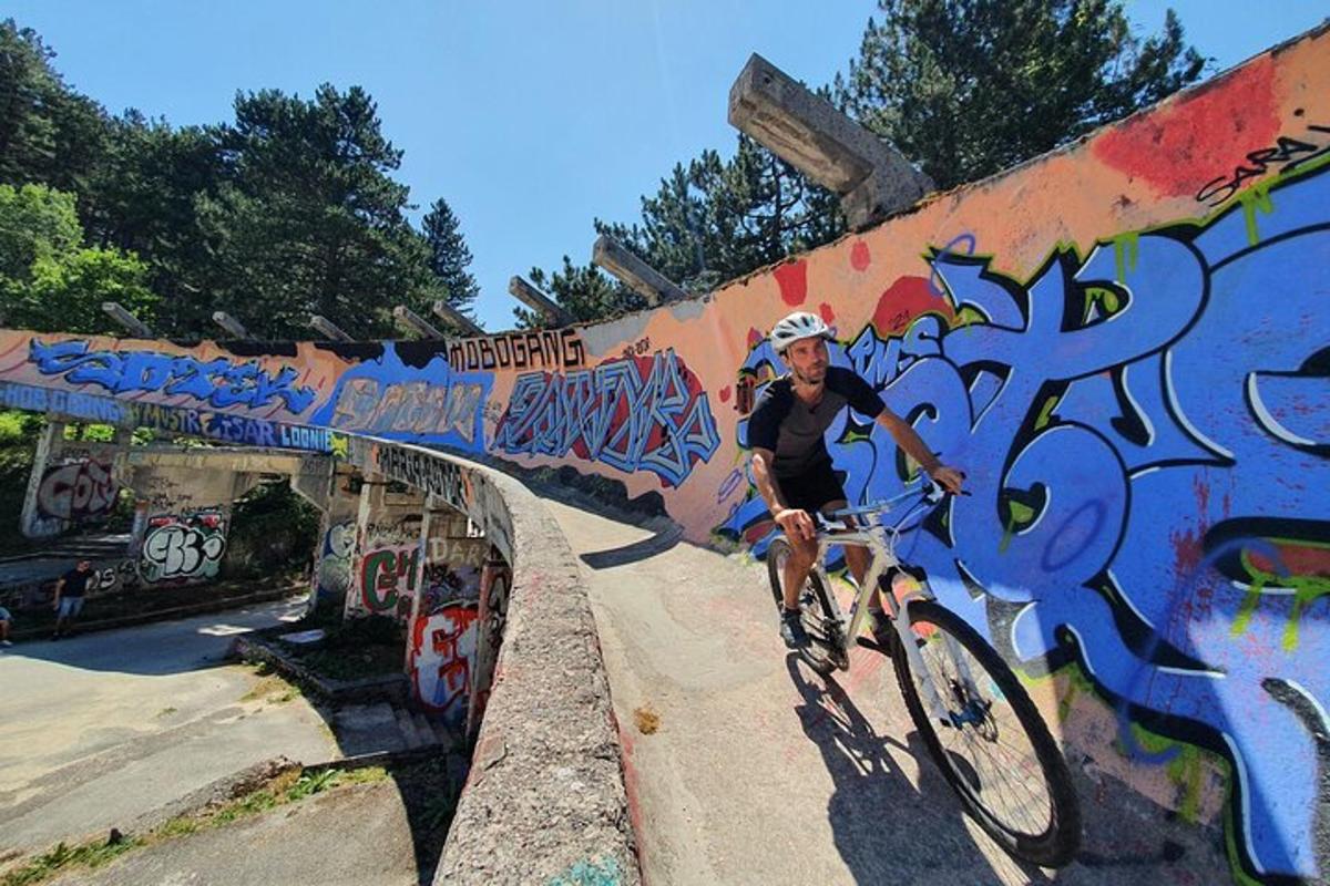 một người đàn ông đang đạp xe trên một cây cầu có mái che bằng graffiti