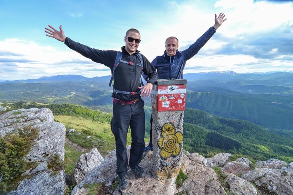 dva muži stojí na vrcholu hory