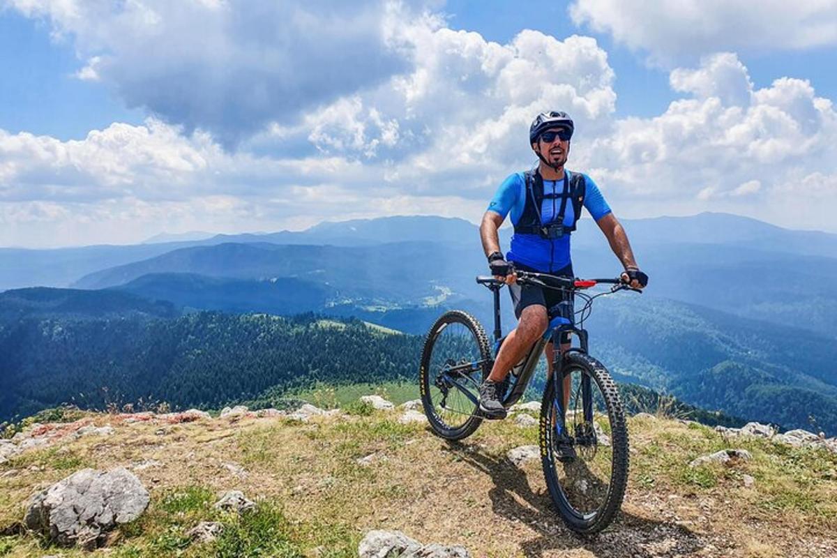 un bărbat care merge cu bicicleta pe vârful unui munte