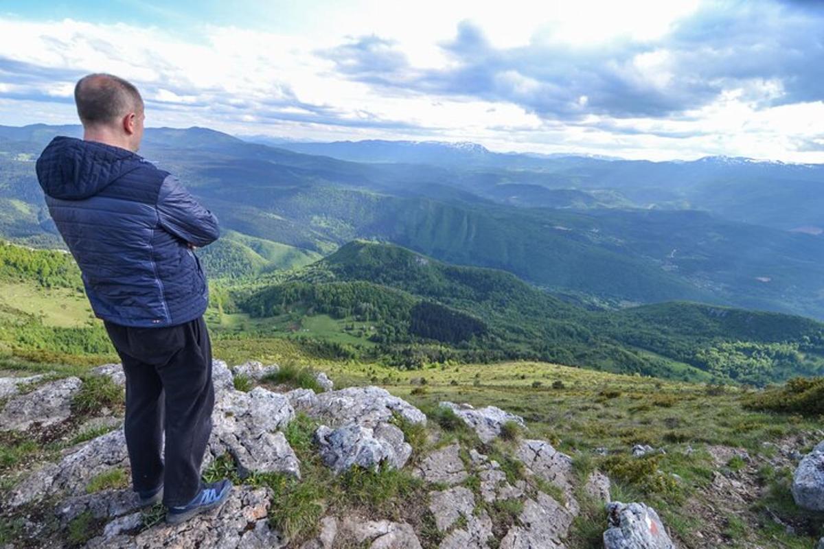 muž stojící na vrcholu hory