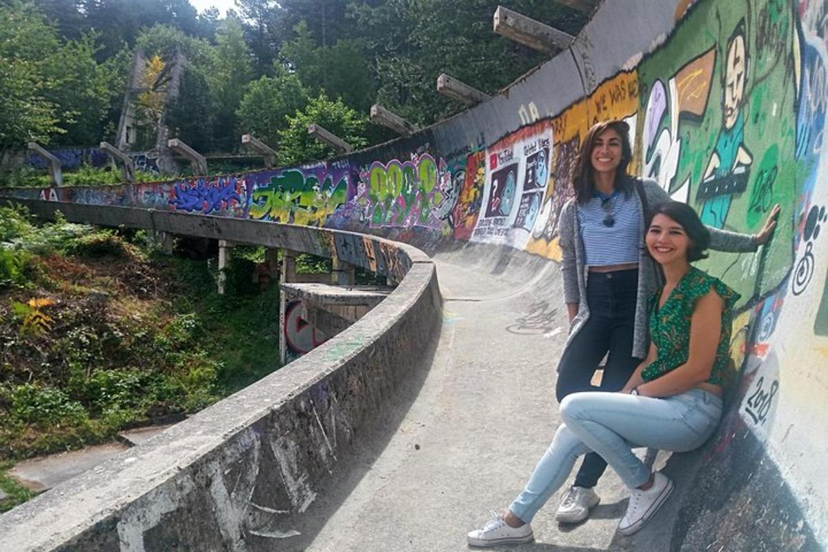 dvě dívky sedící na zdi s graffiti