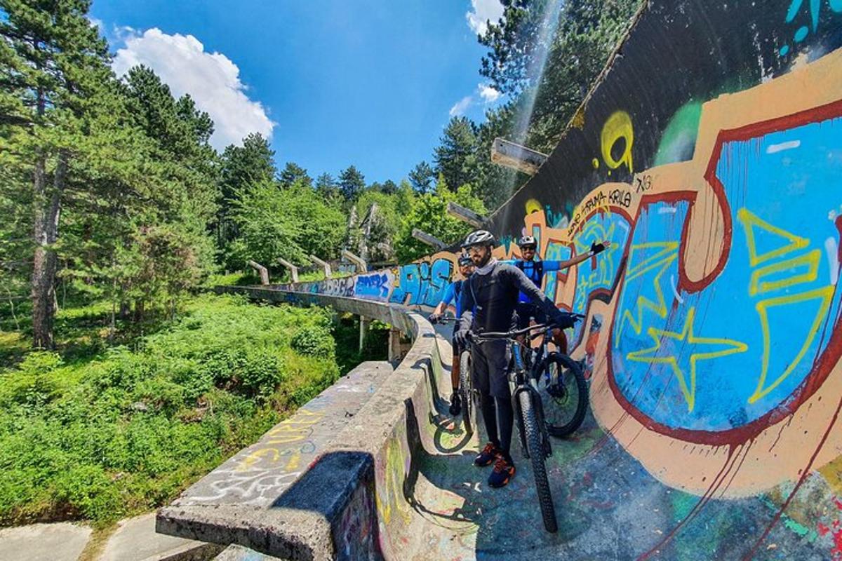 một người đang đạp xe trên bức tường có hình vẽ graffiti