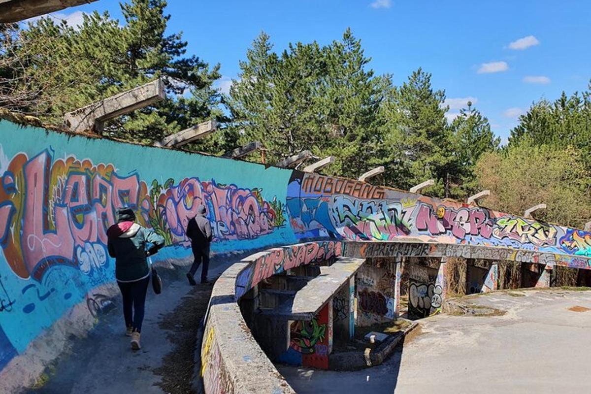 to personer som går under en graffitidekket bro