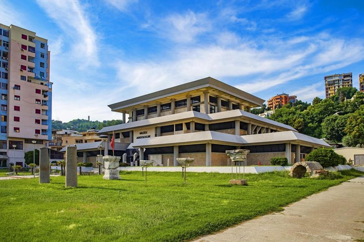 a large building with a grass field in front of it