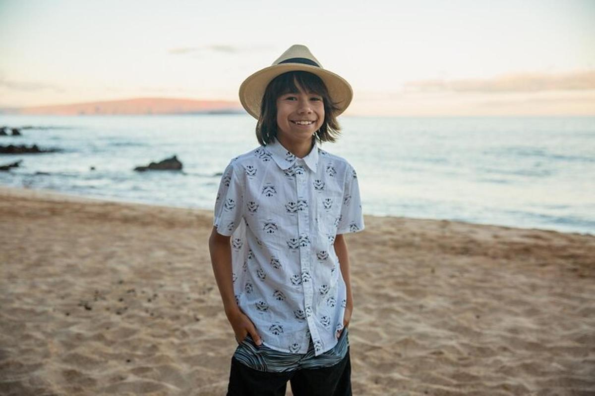 en kvinne med hatt som står på stranden