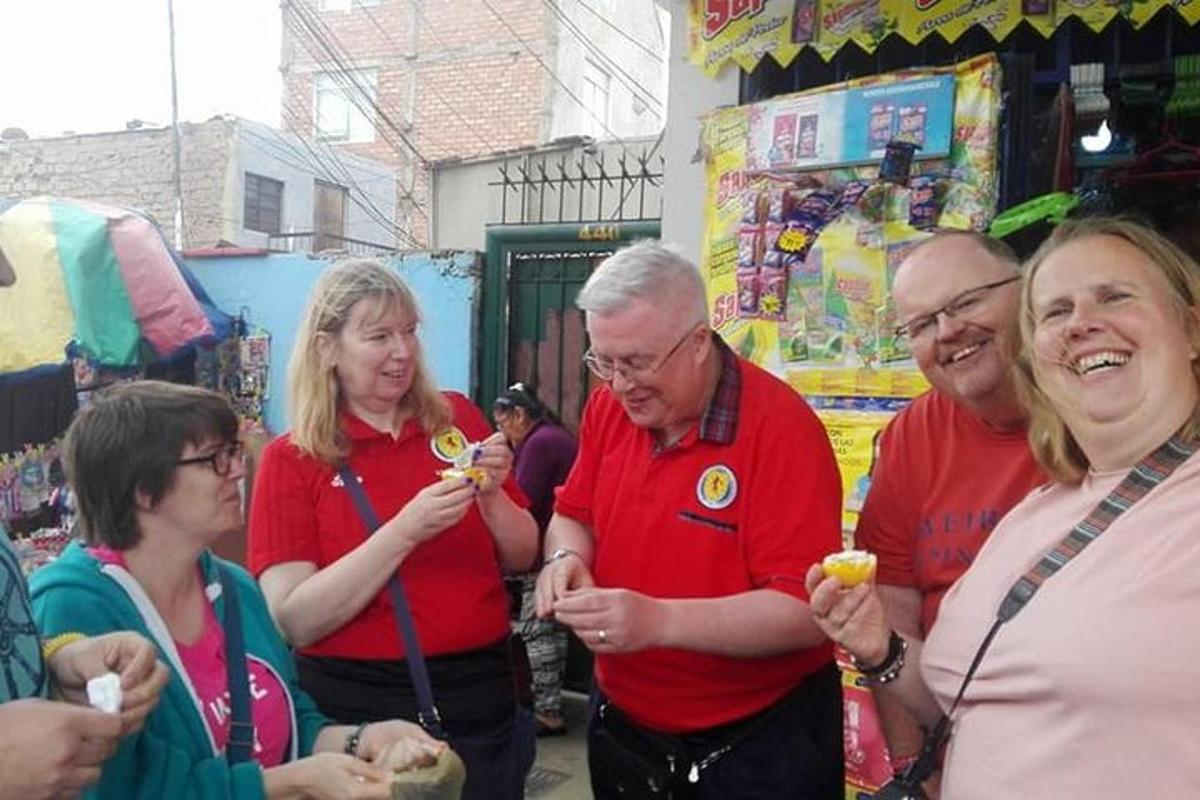 un gruppo di persone che mangiano cibo in un negozio