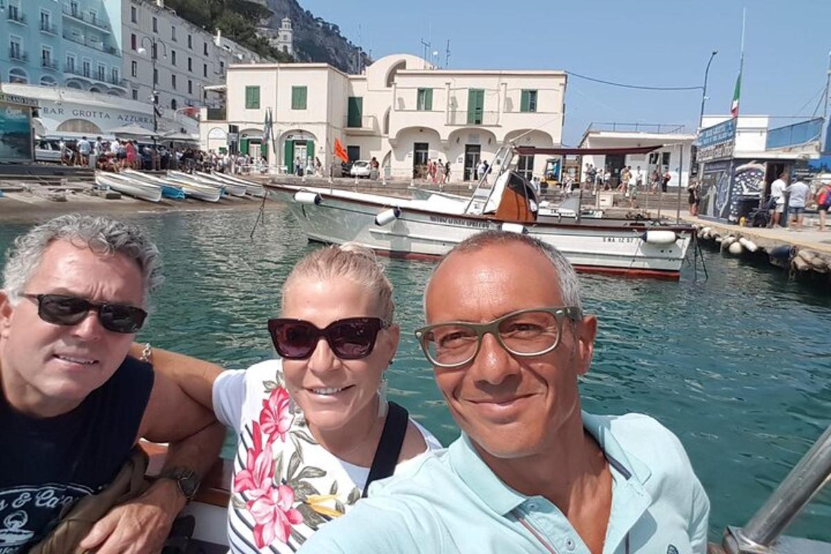 tre persone su una barca in uno specchio d'acqua