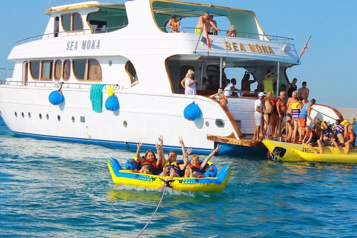 skupina ljudi v splavih v vodi poleg čolna