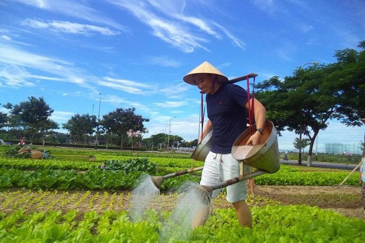 un uomo che indossa un cappello di paglia che annaffia un campo