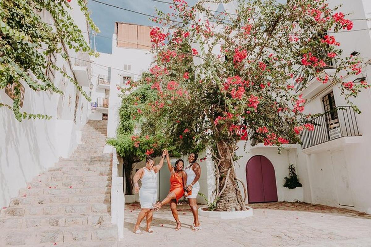 a group of three women posing under a tree with flowers