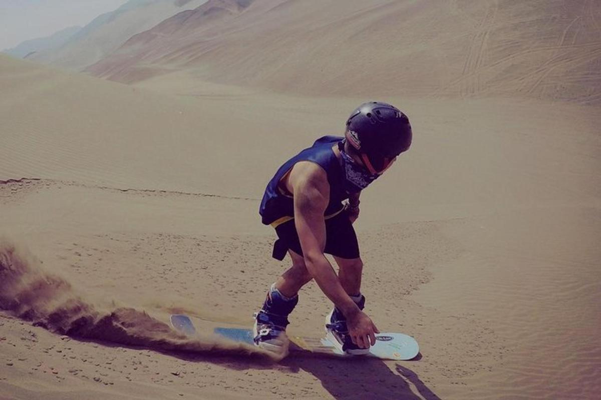 muž stojící na snowboardu v poušti