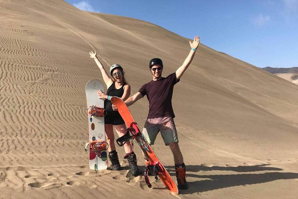 muž a žena stojící v poušti se svými snowboardy