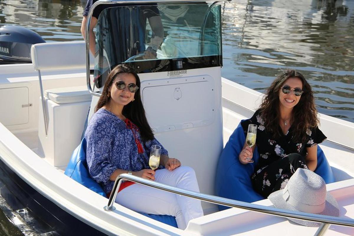 Dos mujeres sentadas en un bote con copas de vino