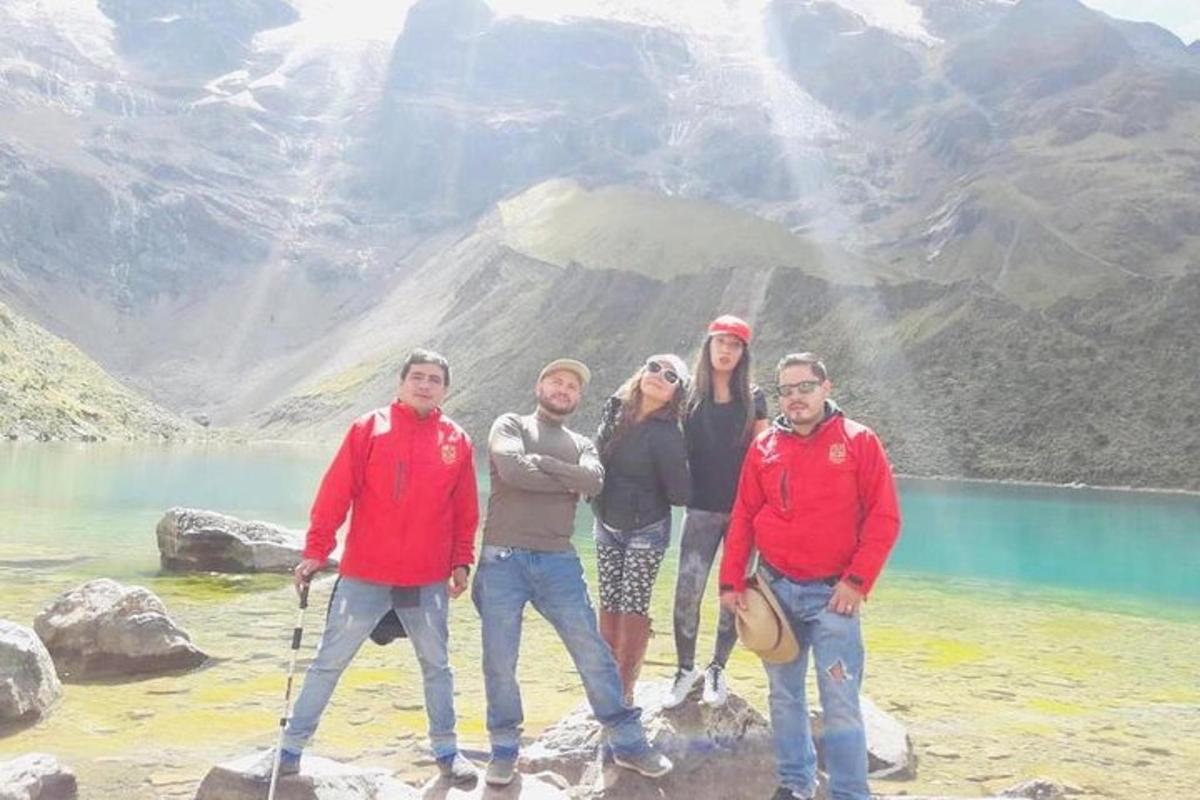 Un grupo de personas de pie sobre una roca cerca de un lago.