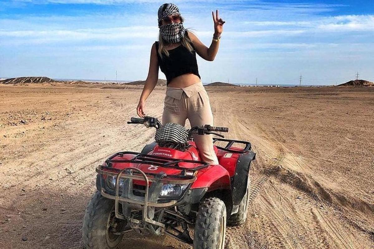 eine Frau steht auf einem Quad in der Wüste