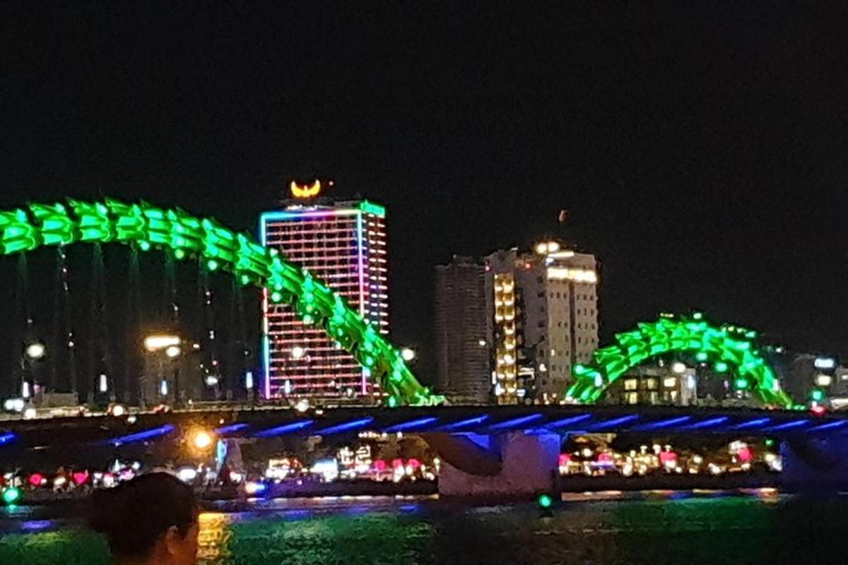 Un puente verde en una ciudad por la noche.