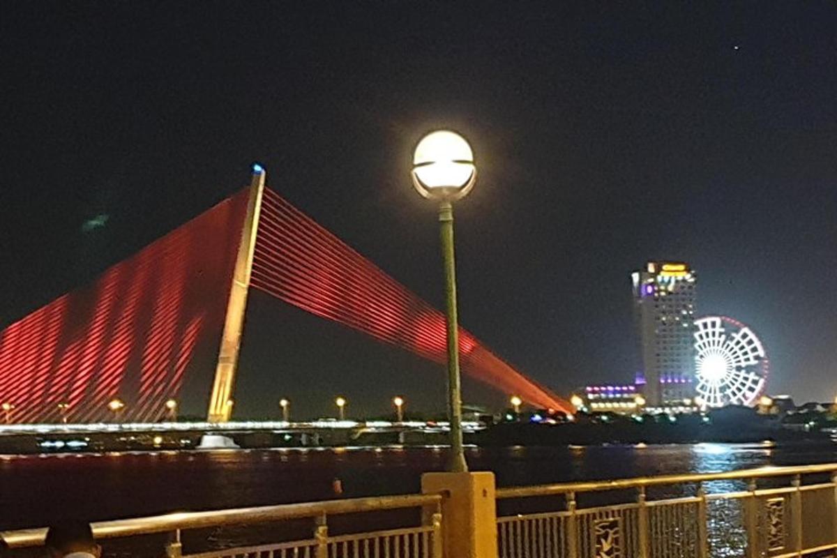 una farola frente a un puente por la noche