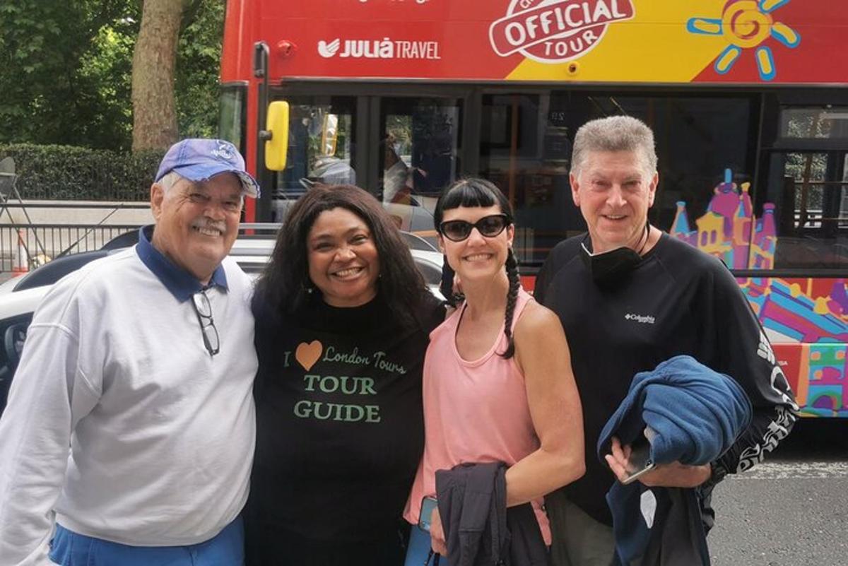 um grupo de três pessoas em pé na frente de um ônibus